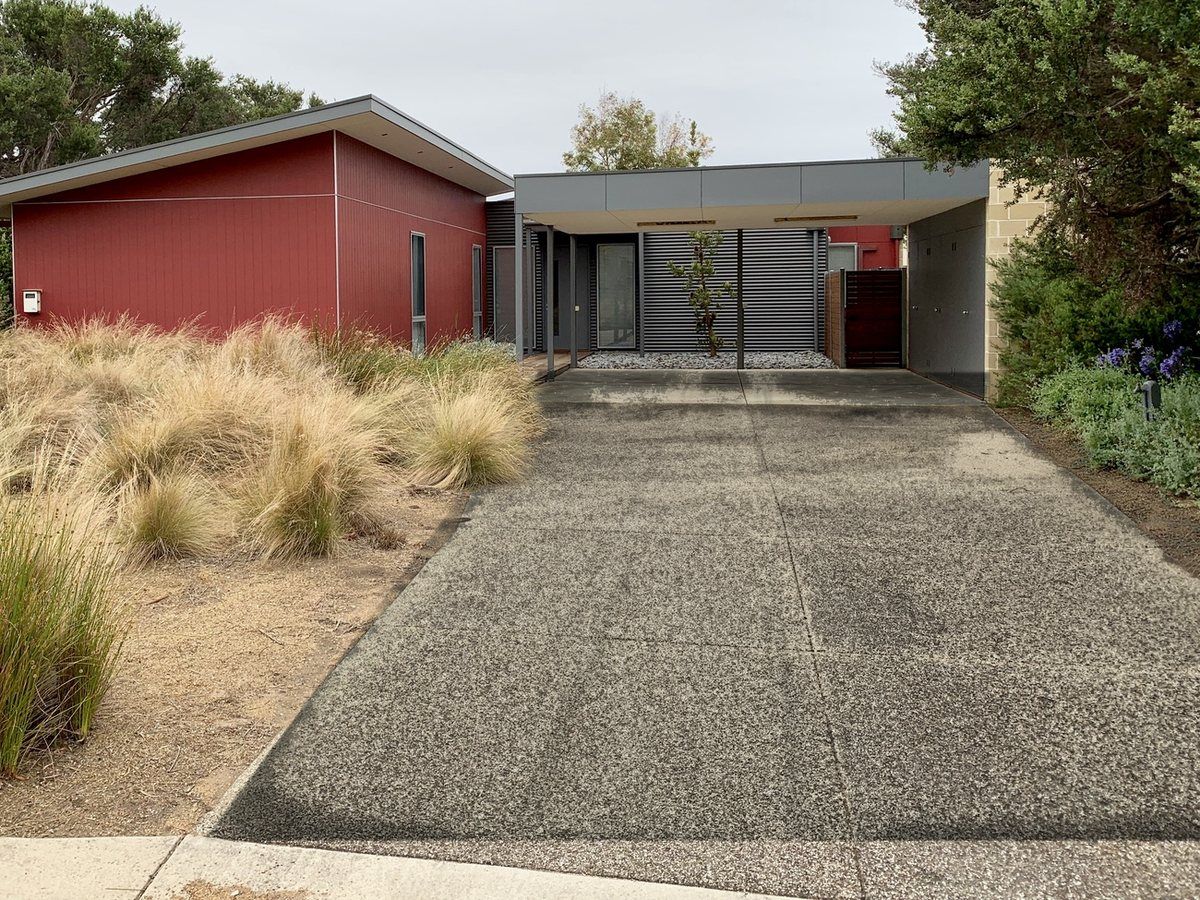 Exposed aggregate driveway before cleaning, darkened by mould